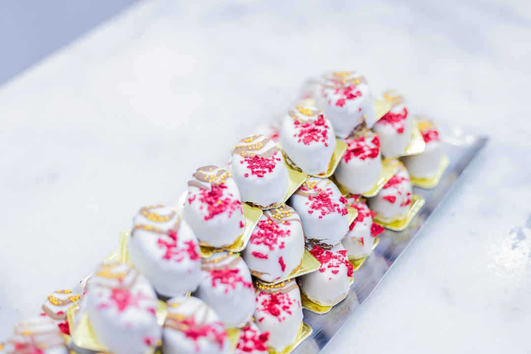 Rows of small white mini cakes on a tray